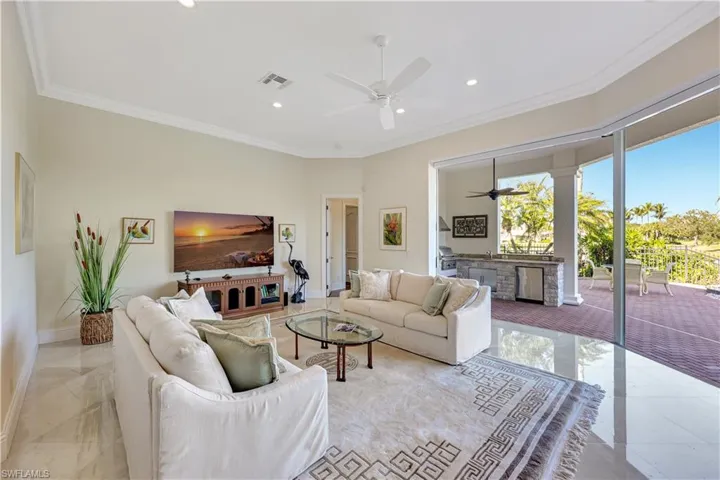 Living room featuring ornamental molding, recessed lighting, and a ceiling fan