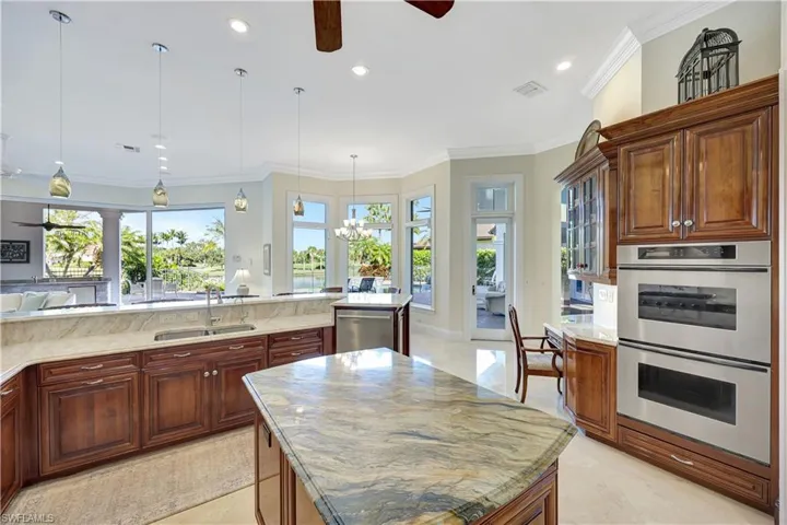 Kitchen with crown molding, stainless steel appliances, decorative light fixtures, a center island, and recessed lighting