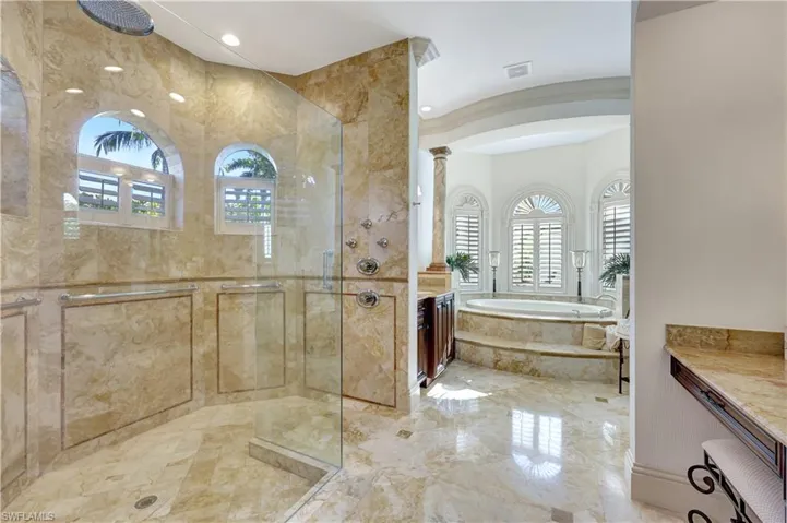 Bathroom featuring vanity, a garden tub, a stall shower, light marble finish floors, and recessed lighting