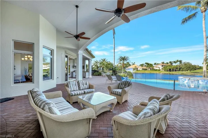 View of patio / terrace with a pool with connected hot tub, a water view, a ceiling fan, and an outdoor living space