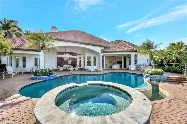 View of pool with a patio with connected hot tub
