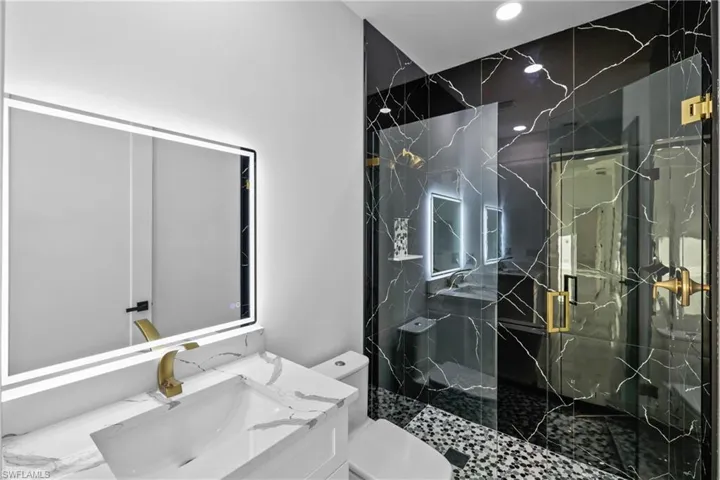 Bathroom featuring vanity, toilet, and walk in shower