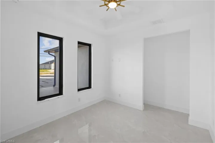 Unfurnished room featuring ceiling fan and a tray ceiling
