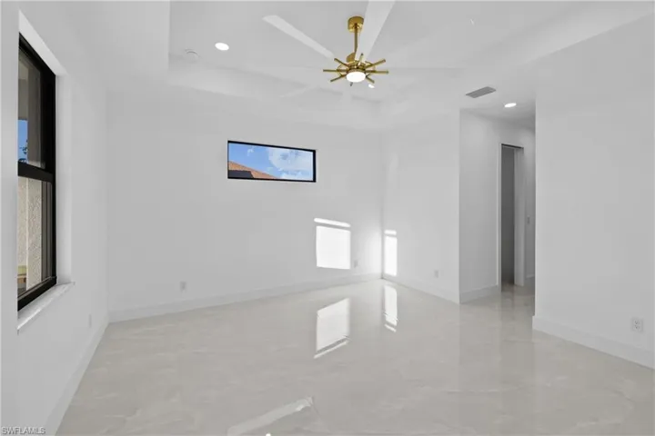 Unfurnished room with a tray ceiling and ceiling fan