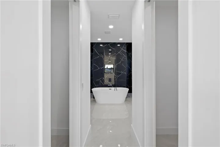 Bathroom featuring a tub to relax in and tile walls