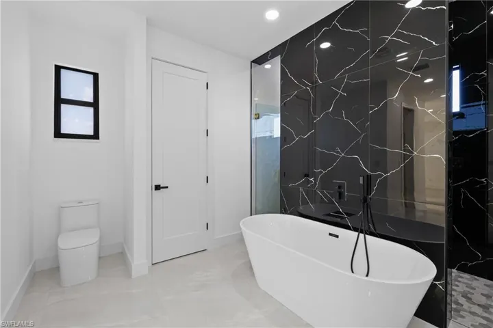 Bathroom featuring a bath and toilet