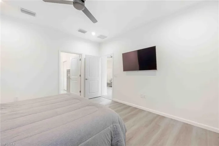 Bedroom featuring light wood-style flooring, baseboards, and visible vents