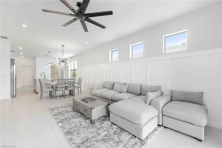 Living area featuring visible vents, a stone fireplace, ceiling fan, recessed lighting, and light tile patterned flooring