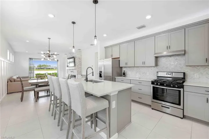 Kitchen featuring gray cabinets, a sink, and appliances with stainless steel finishes
