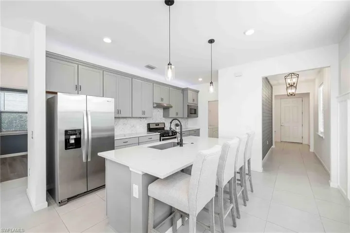 Entry, Hallway and Kitchen featuring gray cabinets, a sink, and appliances with stainless steel finishes
