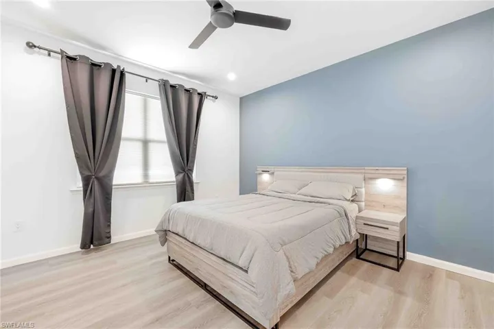 Bedroom featuring light wood finished floors, baseboards, and a ceiling fan