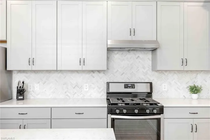 Kitchen featuring gray cabinets, a sink, and appliances with stainless steel finishes