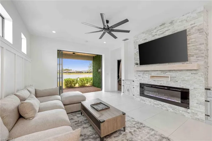 Living area featuring visible vents, a stone fireplace, ceiling fan, recessed lighting, and light tile patterned flooring