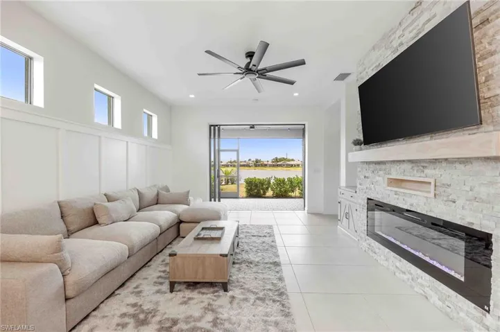 Living area featuring visible vents, a stone fireplace, ceiling fan, recessed lighting, and light tile patterned flooring