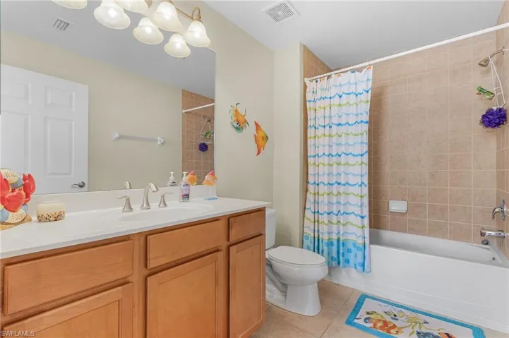 Full bathroom featuring tile patterned flooring, vanity, toilet, and shower / bath combo
