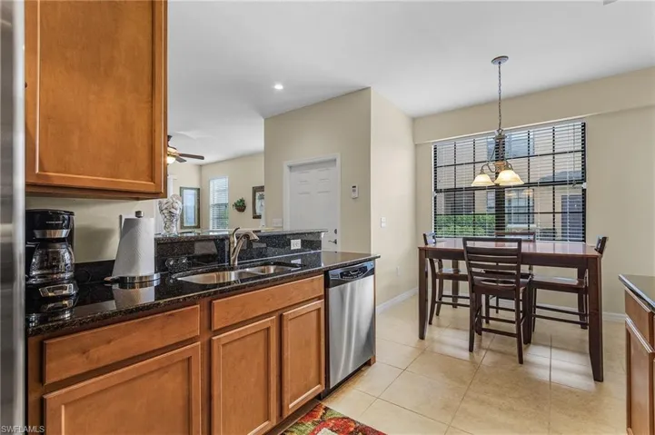 Kitchen with plenty of natural light, decorative light fixtures, stainless steel dishwasher, and ceiling fan