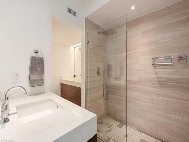 Bathroom with visible vents, vanity, and a walk in shower