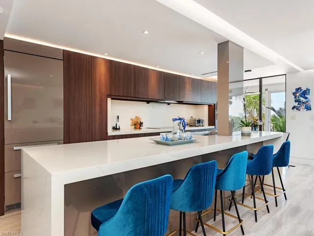 Kitchen featuring a breakfast bar, light wood-style flooring, built in refrigerator, and modern cabinets