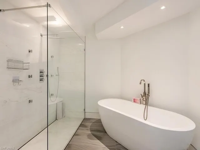 Bathroom with a marble finish shower, a soaking tub, and recessed lighting