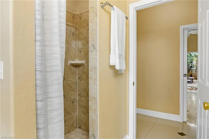 Bathroom featuring a shower with curtain and tile patterned flooring