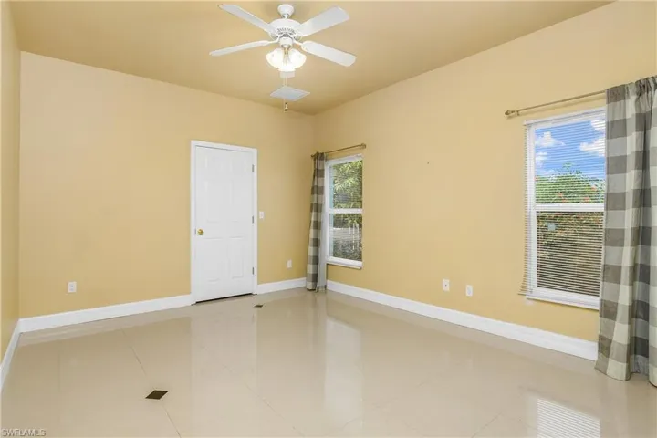 Tiled spare room with ceiling fan