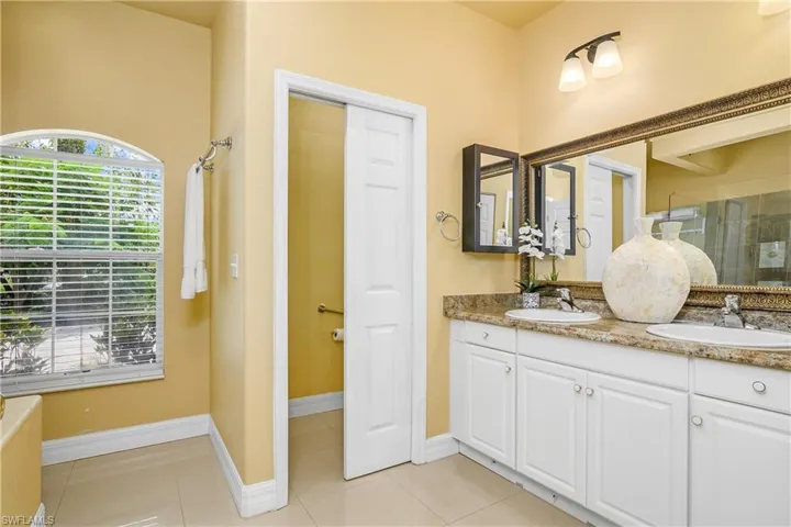 Bathroom featuring tile patterned floors and dual bowl vanity