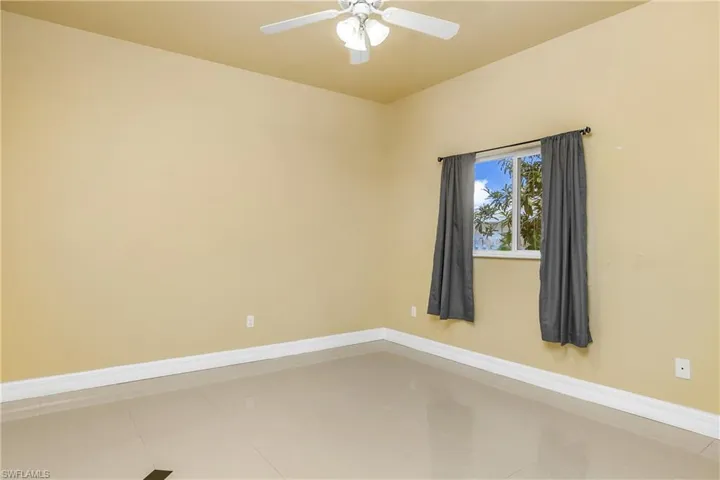 Spare room with ceiling fan and tile patterned flooring