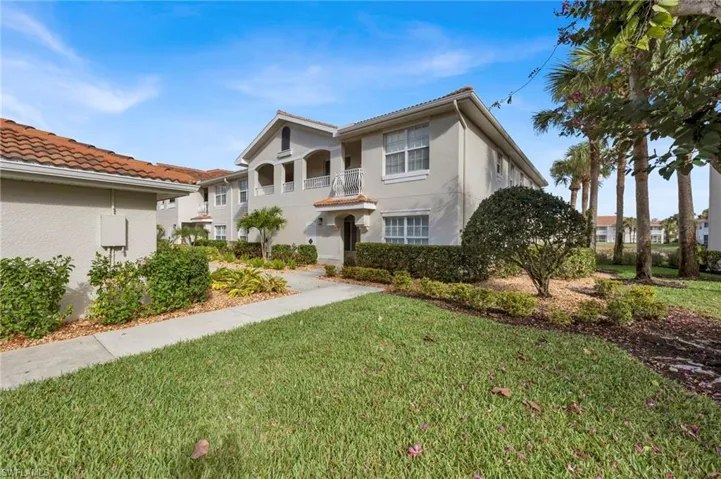 Mediterranean / spanish home featuring a front yard, stucco siding, a tile roof, and a balcony