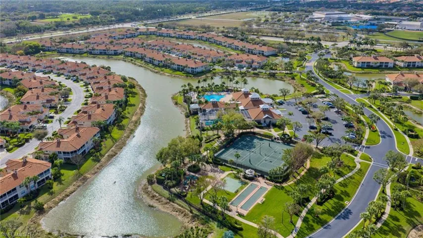 Aerial view of property and surrounding area featuring a nearby body of water and nearby suburban area