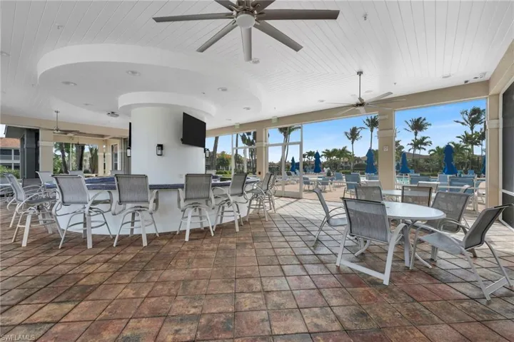 View of patio with ceiling fan and an outdoor bar and dining area