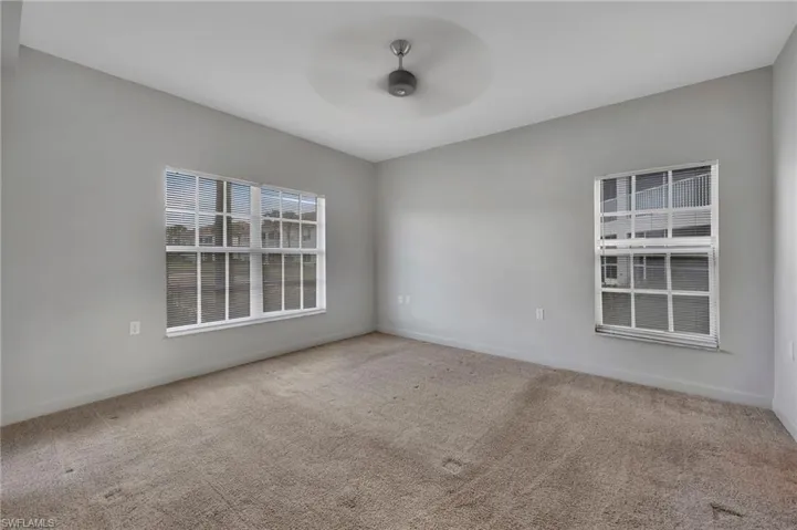 Spare room with light colored carpet and ceiling fan