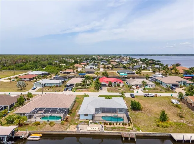 Waterfront property featuring a screened-in pool, private dock, and direct canal access
