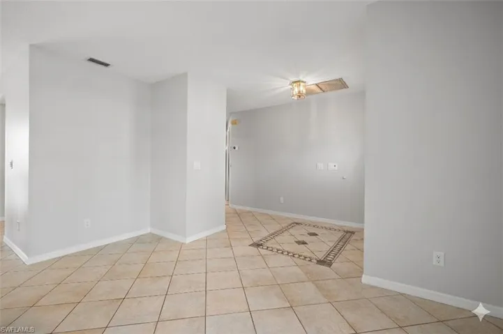 Light-toned ceramic tile flooring with a decorative inset pattern