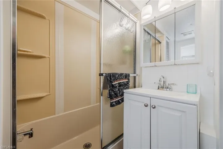 Full bathroom with vanity and a shower with shower door
