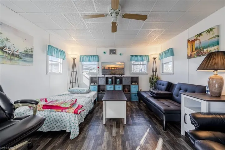 Living room with dark wood-type flooring and a ceiling fan