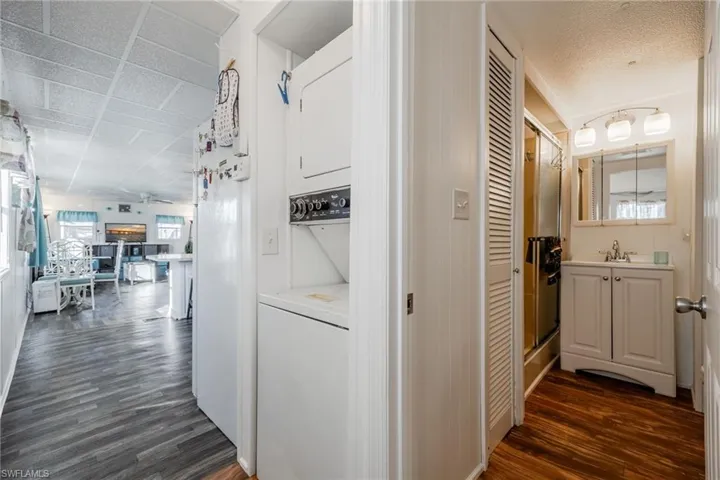 Corridor with a textured ceiling, dark wood-type flooring, and a sink