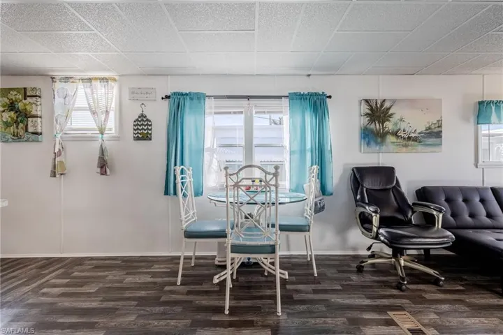 Dining space featuring wood finished floors, a healthy amount of sunlight, and baseboards