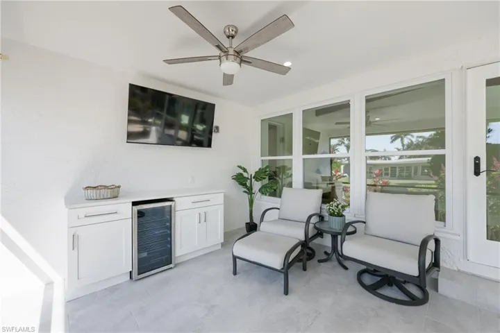 View of patio with exterior kitchen, wine cooler, and ceiling fan