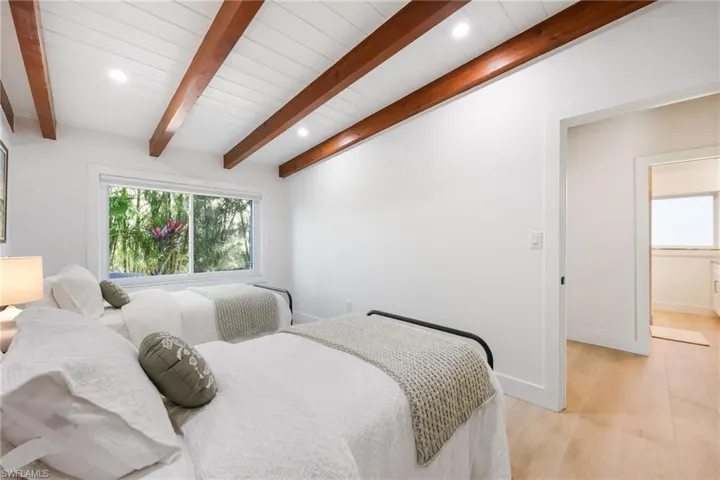 Bedroom featuring recessed lighting, beamed ceiling, light wood-style flooring, and baseboards