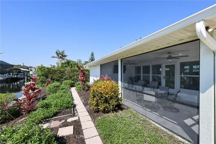 View of yard featuring a sunroom and ceiling fan