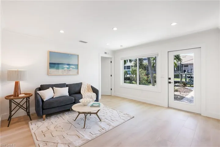 Living area featuring baseboards, light wood finished floors, visible vents, and recessed lighting