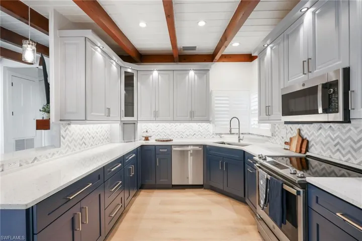 Kitchen with stainless steel appliances, blue cabinetry, and a sink