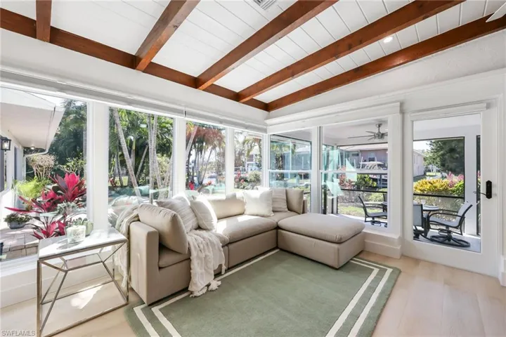 Sunroom featuring lofted ceiling with beams