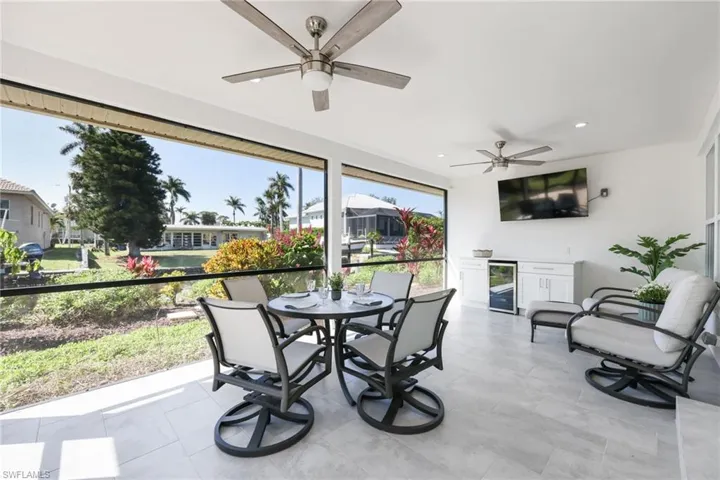 Sunroom with wine cooler and a ceiling fan