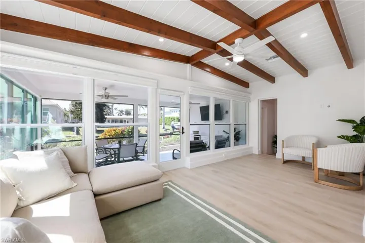 Living room featuring lofted ceiling with beams, ceiling fan, wooden ceiling, recessed lighting, and wood finished floors