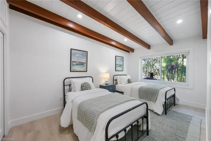 Bedroom with light wood-style flooring, baseboards, beamed ceiling, and recessed lighting