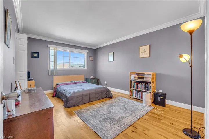 Bedroom featuring light wood floors and ornamental molding