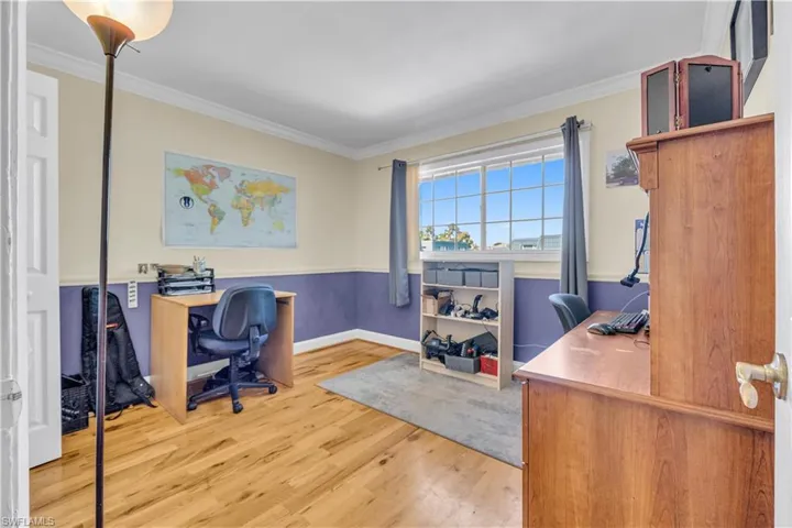 Office featuring light wood-style floors and crown molding
