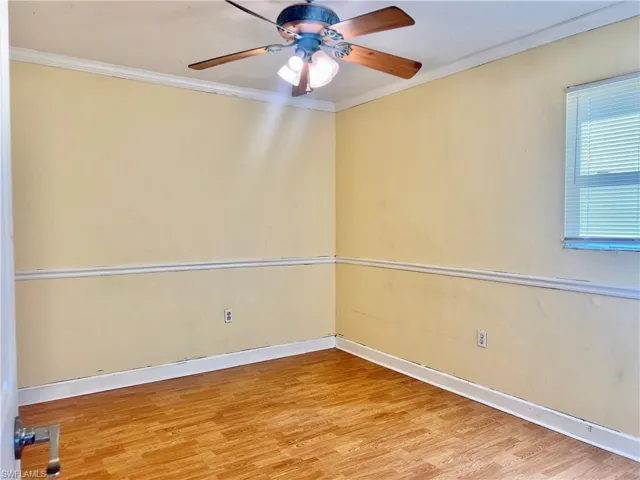 Spare room with hardwood / wood-style flooring, ceiling fan, and ornamental molding