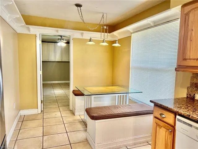 Kitchen with ceiling fan, dishwasher, light tile patterned flooring, and hanging light fixtures